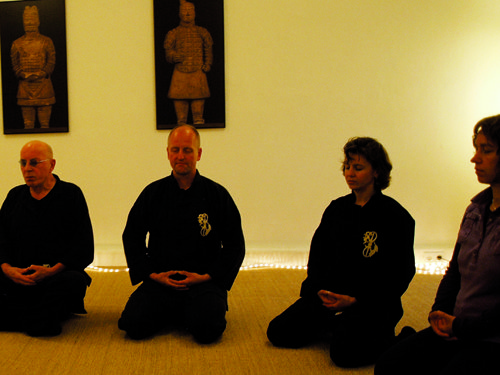 Eine Gruppe älterer Qi Gong Schüler mit Lehrer beim Meditieren.